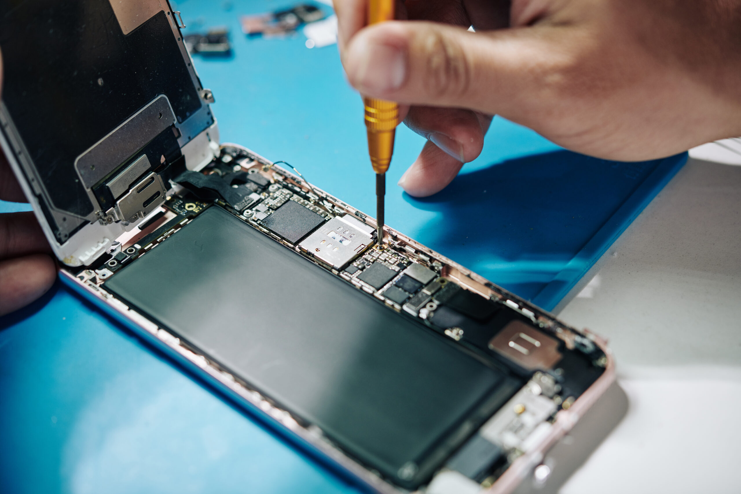 iPhone wordt geopend met een schroevendraaier tijdens een reparatie